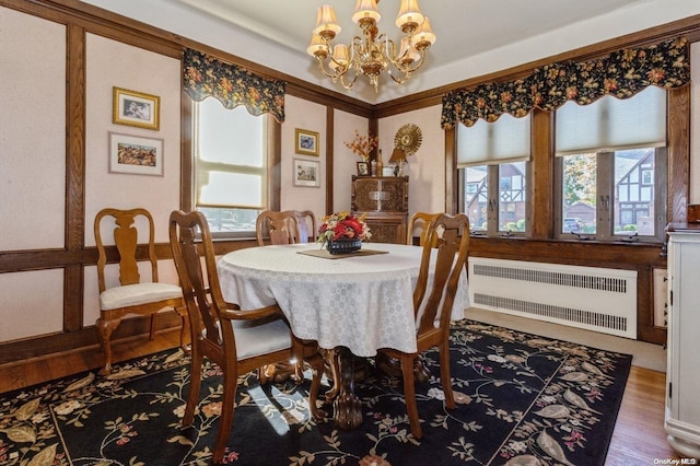 dining room featuring radiator, plenty of natural light, dark hardwood / wood-style floors, and an inviting chandelier