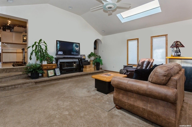 carpeted living room featuring ceiling fan and vaulted ceiling with skylight