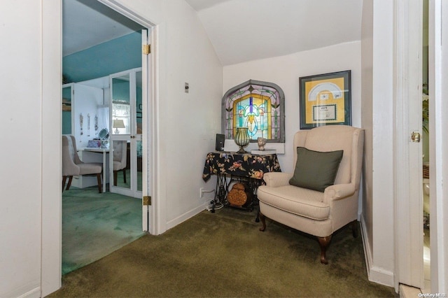 sitting room featuring lofted ceiling and dark colored carpet