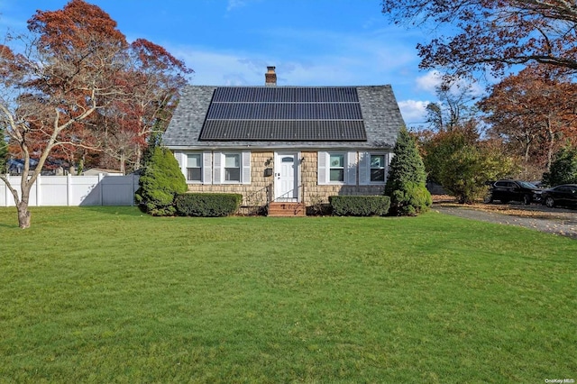 view of front facade featuring solar panels and a front yard