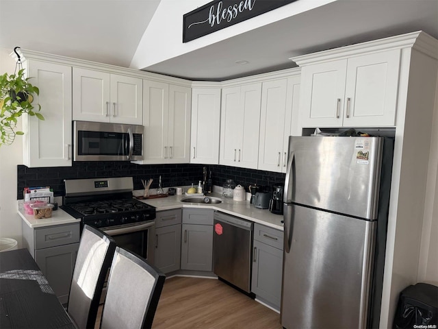 kitchen featuring stainless steel appliances, white cabinetry, gray cabinetry, and sink