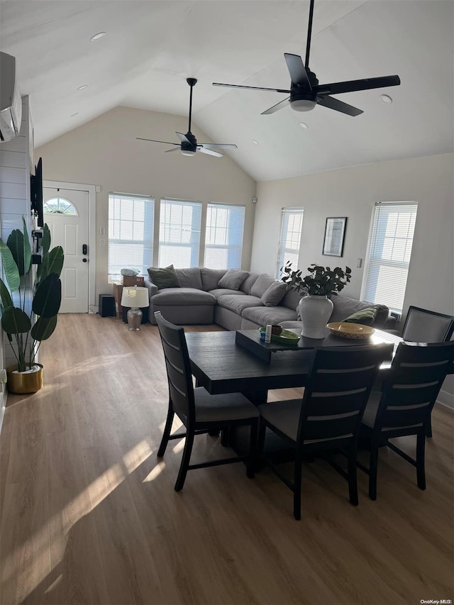 dining space featuring hardwood / wood-style floors, vaulted ceiling, and a wealth of natural light