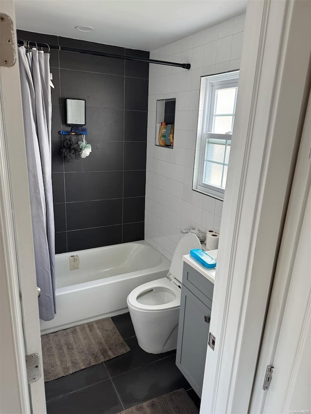 full bathroom featuring shower / bath combo, vanity, tile patterned flooring, toilet, and tile walls