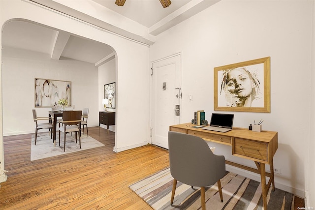 office space with beamed ceiling, light wood-type flooring, and ceiling fan