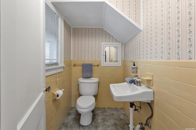 bathroom featuring sink, toilet, tile walls, and tile patterned floors