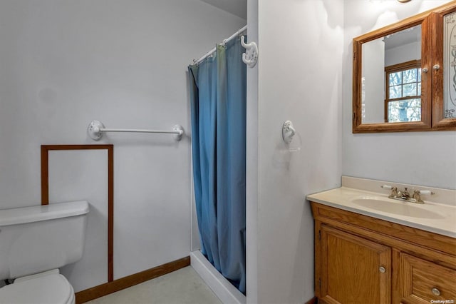 bathroom featuring toilet, vanity, and walk in shower