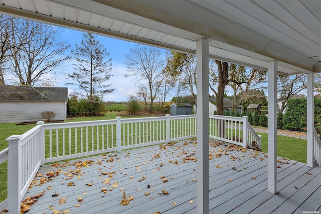 wooden deck with a lawn and a shed