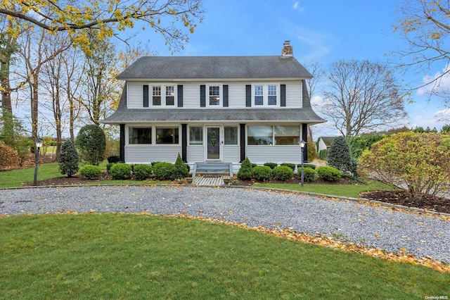 view of front of property with a sunroom and a front yard