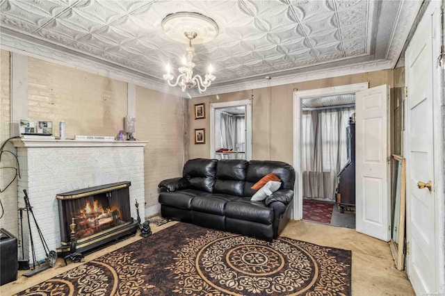 living room featuring crown molding, a fireplace, and a chandelier