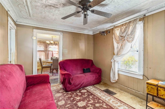 living area featuring ceiling fan with notable chandelier