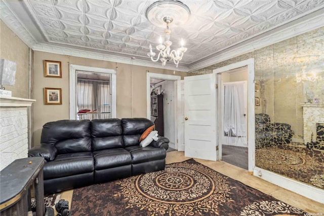 living room featuring crown molding, a fireplace, and an inviting chandelier