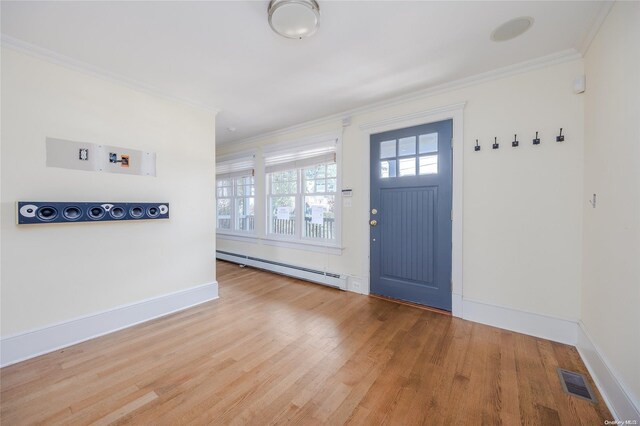 entryway featuring baseboard heating, hardwood / wood-style floors, and ornamental molding