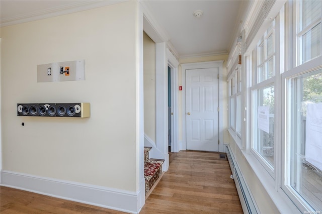hall featuring light hardwood / wood-style floors, a baseboard heating unit, and ornamental molding