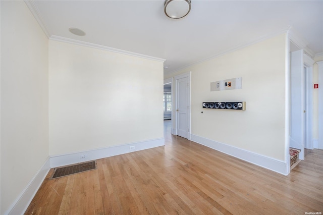 empty room featuring light hardwood / wood-style floors and crown molding