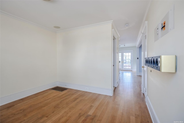 empty room with light hardwood / wood-style floors and crown molding