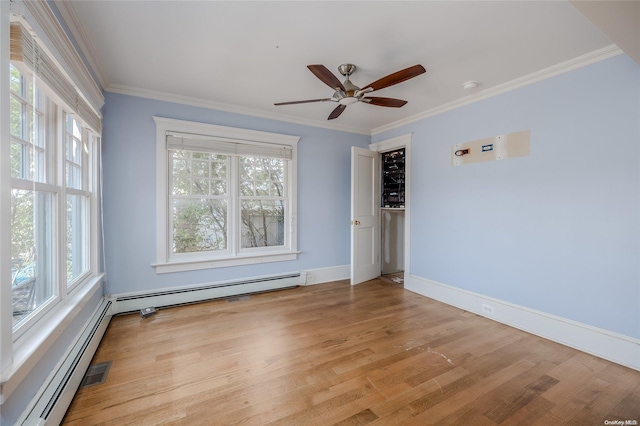 spare room with a baseboard heating unit, light wood-type flooring, ceiling fan, and crown molding
