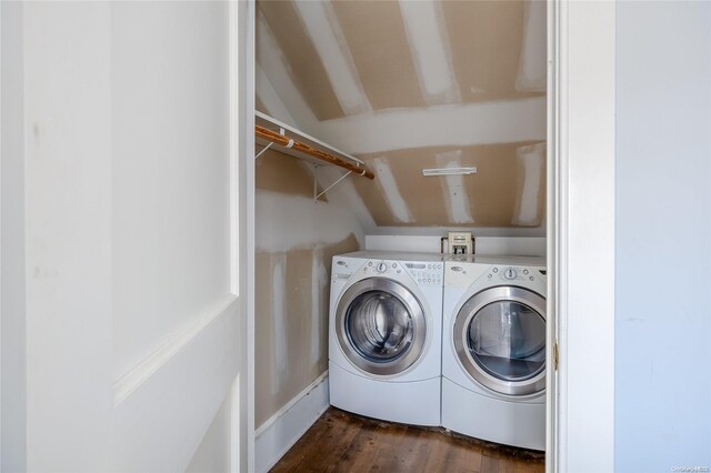 laundry room with washing machine and clothes dryer and dark hardwood / wood-style flooring