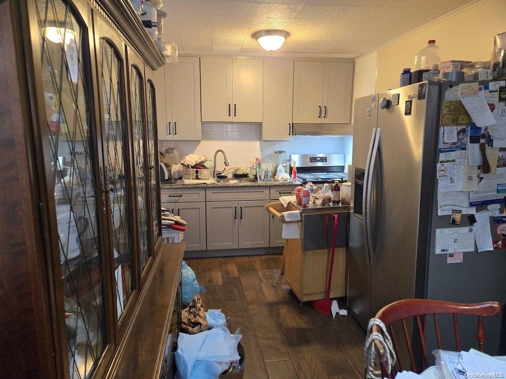 206 W Marshall St, Hempstead, NY 11550 - kitchen with dark wood finished floors, tasteful backsplash, stainless steel appliances, and a sink