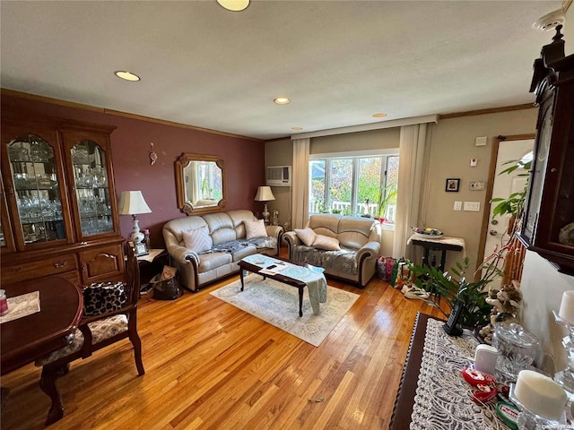 living room with an AC wall unit, light hardwood / wood-style flooring, and ornamental molding