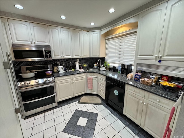 kitchen featuring appliances with stainless steel finishes, sink, light tile patterned floors, dark stone countertops, and decorative backsplash