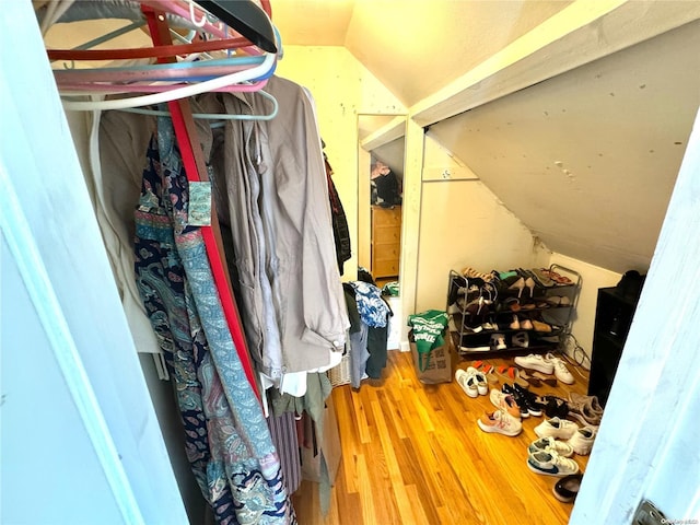 walk in closet featuring hardwood / wood-style flooring and vaulted ceiling