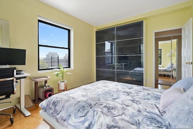 bedroom featuring parquet flooring and a closet