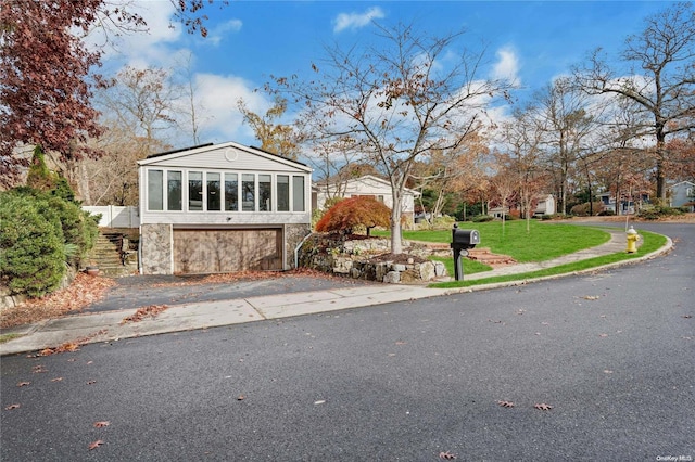 view of front of house featuring a sunroom and a front yard