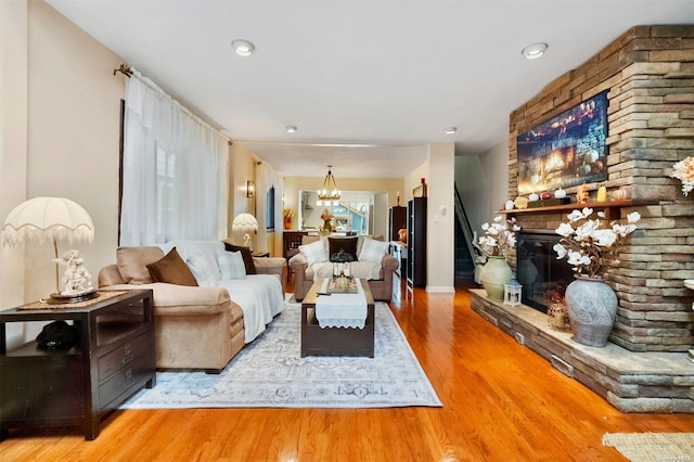 living room featuring a stone fireplace and hardwood / wood-style flooring