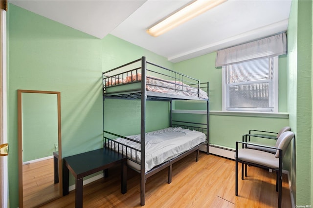 bedroom featuring hardwood / wood-style floors and a baseboard radiator