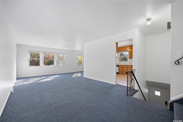 unfurnished living room featuring carpet flooring and a wealth of natural light