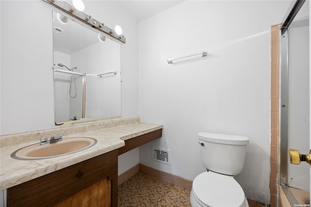 bathroom featuring vanity, toilet, and a shower with door