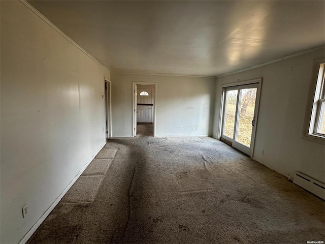 empty room with carpet, ornamental molding, and a baseboard heating unit