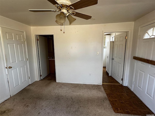 unfurnished bedroom featuring ceiling fan and dark carpet