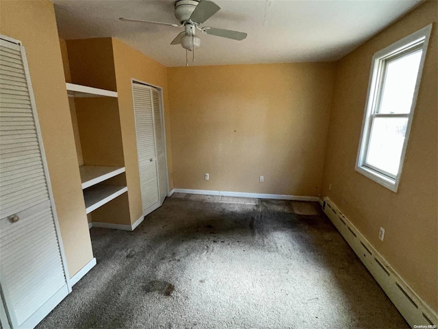 unfurnished bedroom with baseboard heating, ceiling fan, and dark carpet