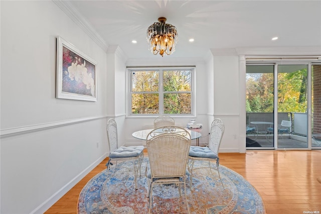 dining room featuring an inviting chandelier, crown molding, and light hardwood / wood-style flooring