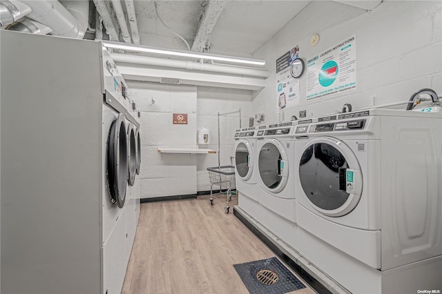 clothes washing area with light hardwood / wood-style floors, independent washer and dryer, and stacked washer and dryer