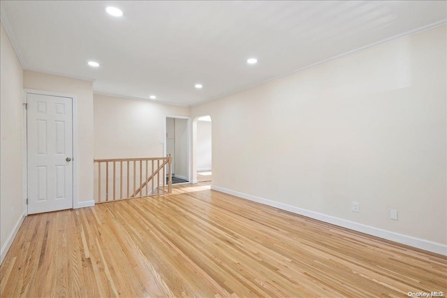 empty room with light hardwood / wood-style floors and ornamental molding