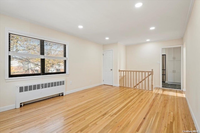 spare room featuring light hardwood / wood-style flooring and radiator