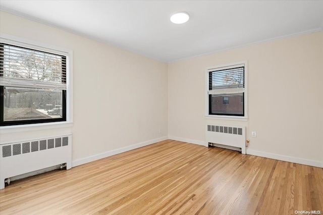 unfurnished room with radiator, light hardwood / wood-style flooring, and ornamental molding