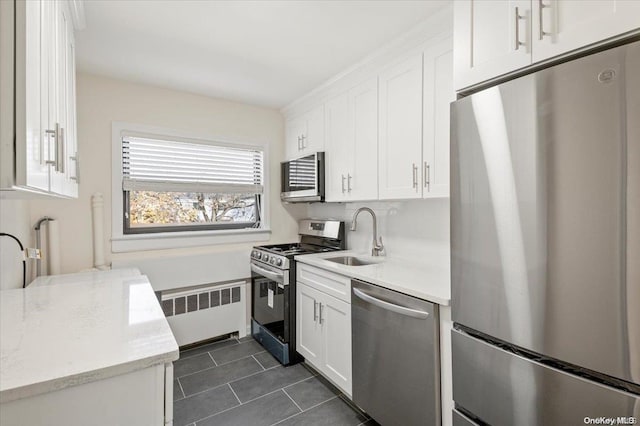 kitchen with radiator, white cabinetry, sink, and appliances with stainless steel finishes