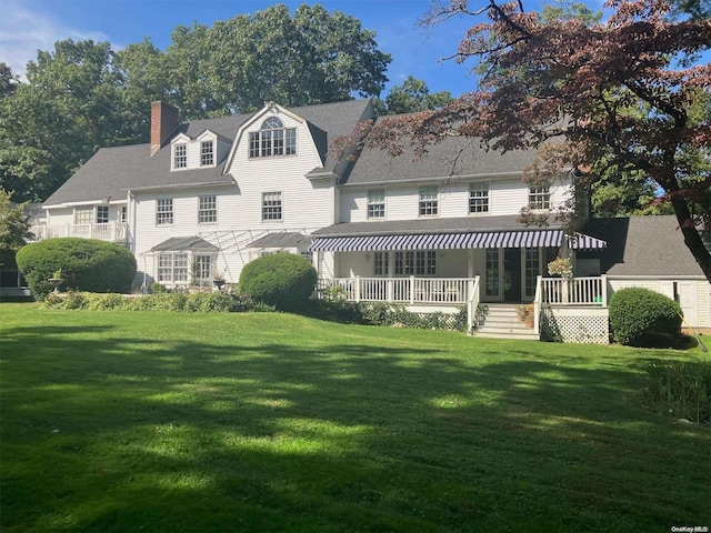 rear view of property with a porch and a yard