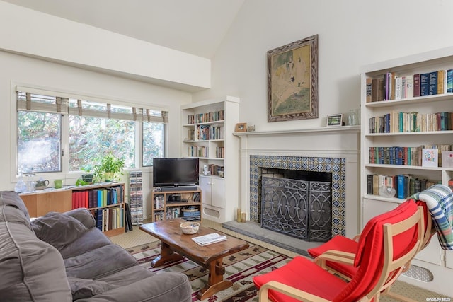 living room with a tile fireplace and vaulted ceiling