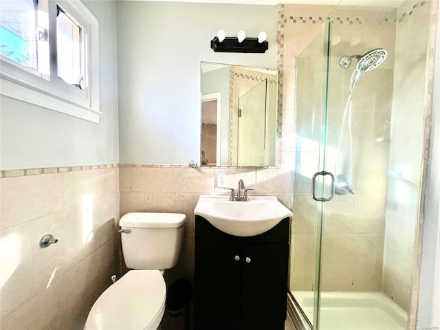 bathroom featuring vanity, toilet, an enclosed shower, and tile walls