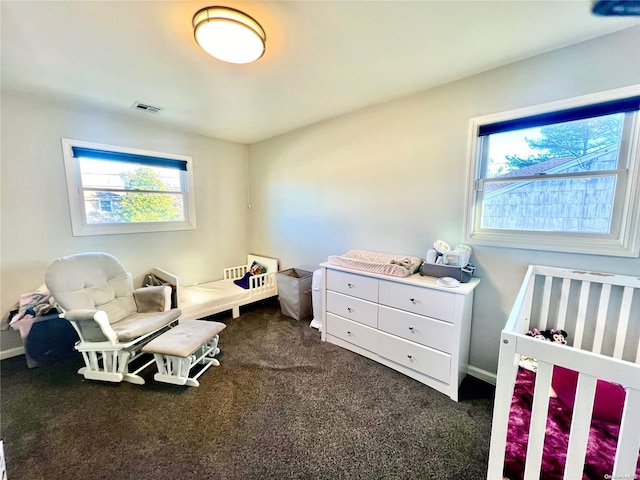 carpeted bedroom featuring a crib and multiple windows