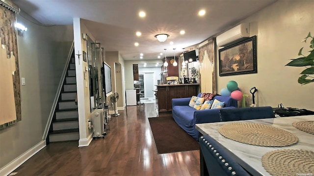 living room with a wall mounted air conditioner and dark hardwood / wood-style floors