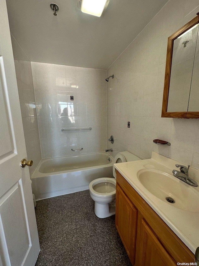 full bathroom featuring vanity, toilet, tile walls, and tiled shower / bath