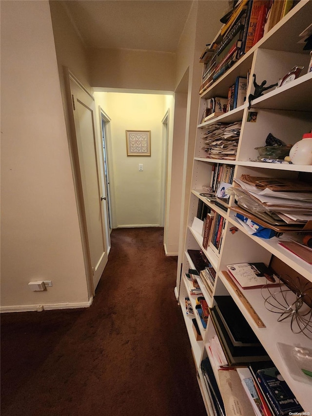 hallway featuring dark colored carpet