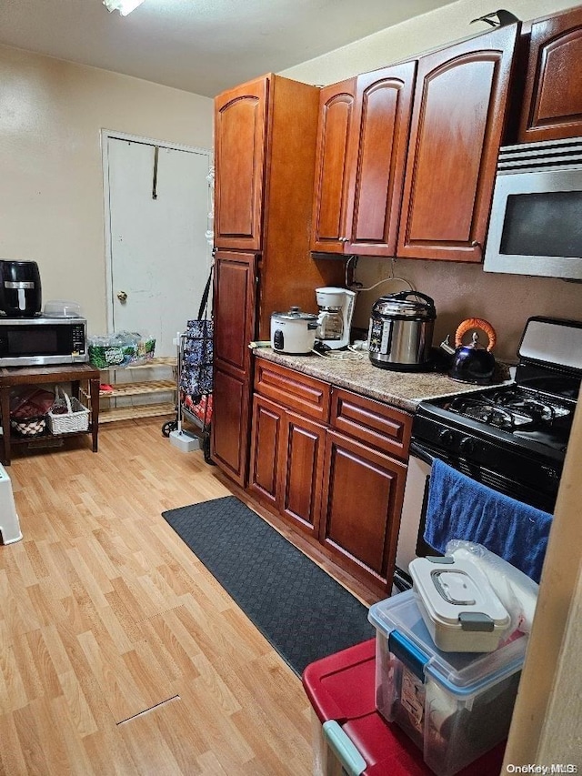 kitchen with light hardwood / wood-style flooring and white range with gas cooktop