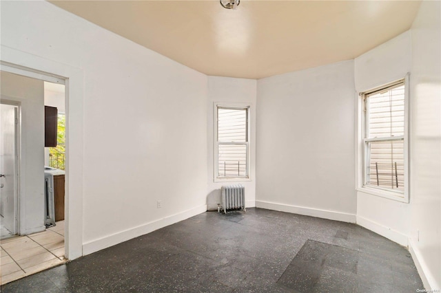 unfurnished room featuring radiator heating unit