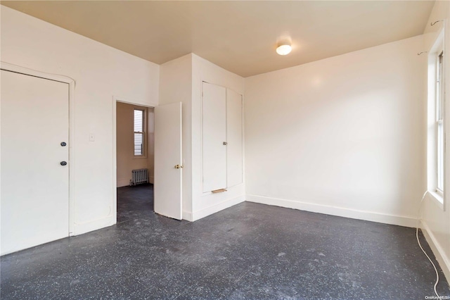 spare room with a healthy amount of sunlight and radiator heating unit